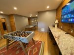 Game room with granite bar tops, barstools, 65 smart TV streaming only, ping pong table, foosball table, board games and access to back patio/yard
